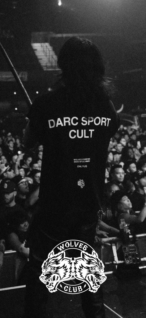 DarcSport - Foto in bianco e nero di una persona che indossa una maglietta Darc Sport Cult a un evento con il logo dei Wolves Club