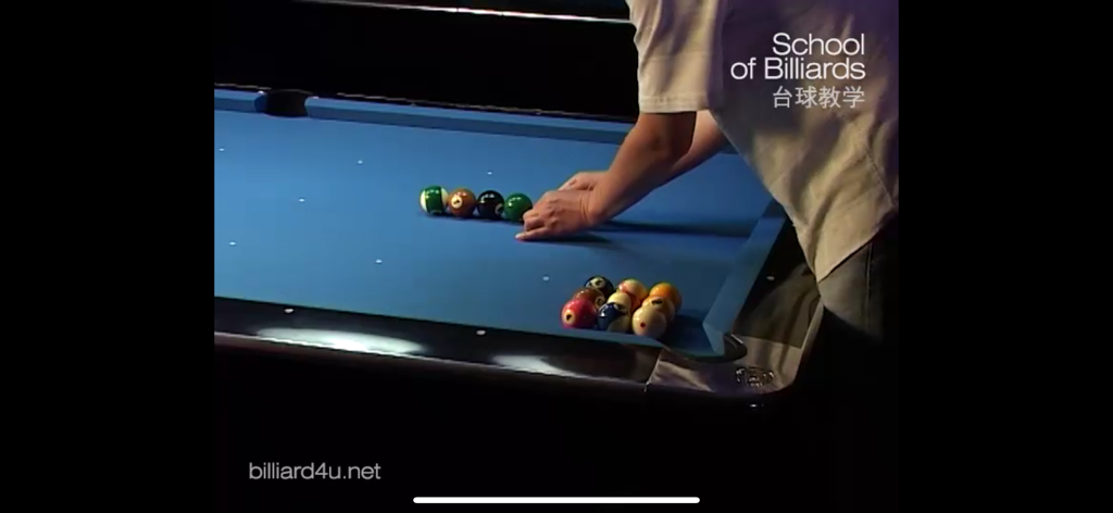 Ein Billardtrainer legt Poolbälle auf einen blauen Tisch für eine chinesische Lehrvideo-Lektion.