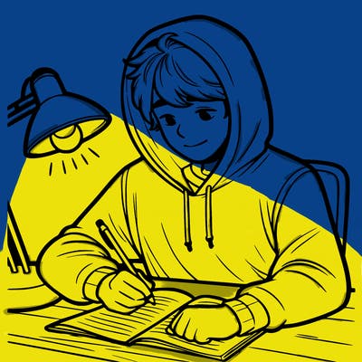 teenage boy with hoodie on writing at his desk with a lamp