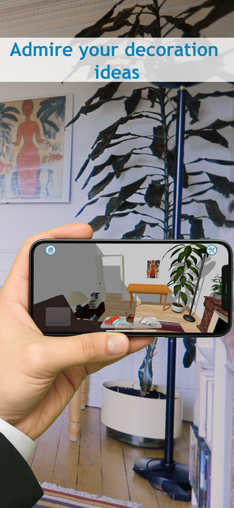 Une main tenant un smartphone montre une modélisation 3D de l'intérieur d'une pièce avec des meubles et des plantes.