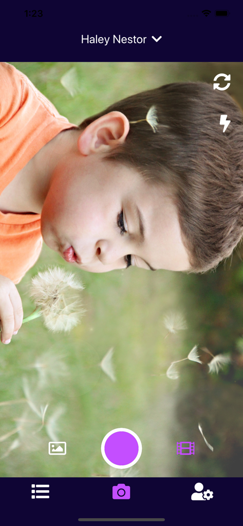 Interfaz de cámara de la aplicación Observer mostrando a un niño soplando un diente de león para la documentación del cuidador.