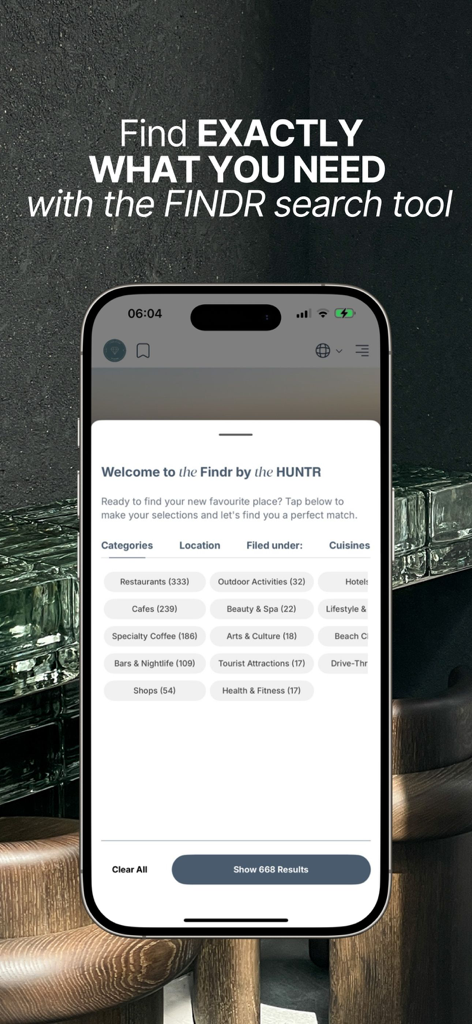 Un smartphone mostrando la herramienta de búsqueda Findr dentro de la aplicación The HUNTR con categorías para restaurantes, cafés y café de especialidad