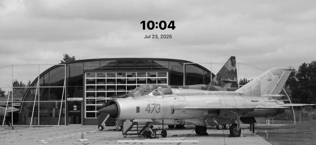 Black and white aircraft photo displayed in the FotoSlide app with a minimal clock overlay