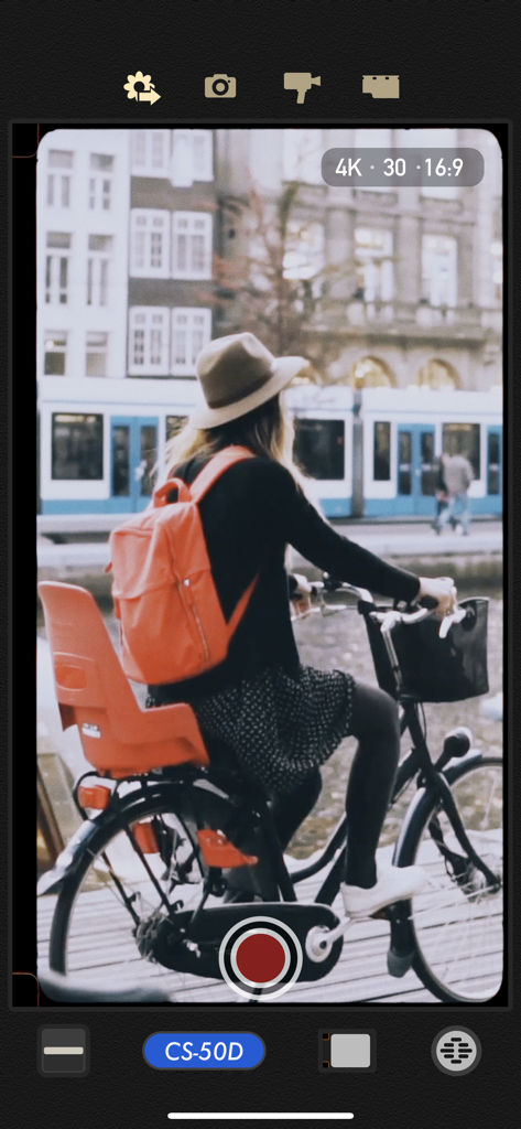 8mm Vintage Camera - 8mm Vintage Camera app interface showing a real time retro film filter while recording a woman on a bicycle