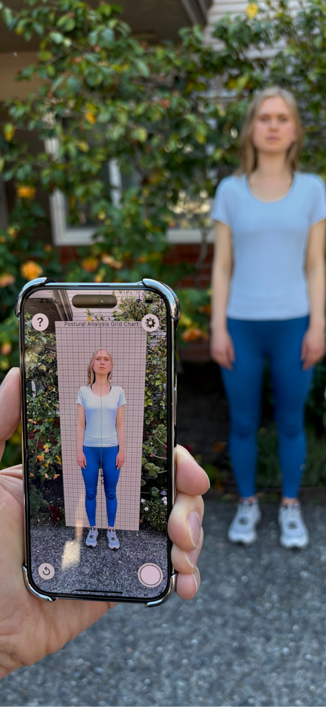 Posture Chart - A person using the Posture Chart app on an iPhone to perform a postural analysis with a digital grid overlay on a patient.