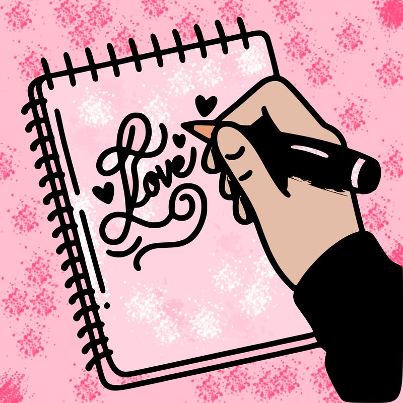 a hand writing “love” in calligraphy on a notebook