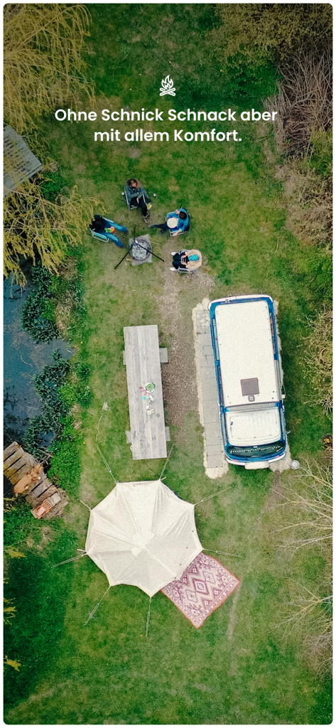 Aerial view of a secluded camping spot with a blue van white tent and friends around a campfire