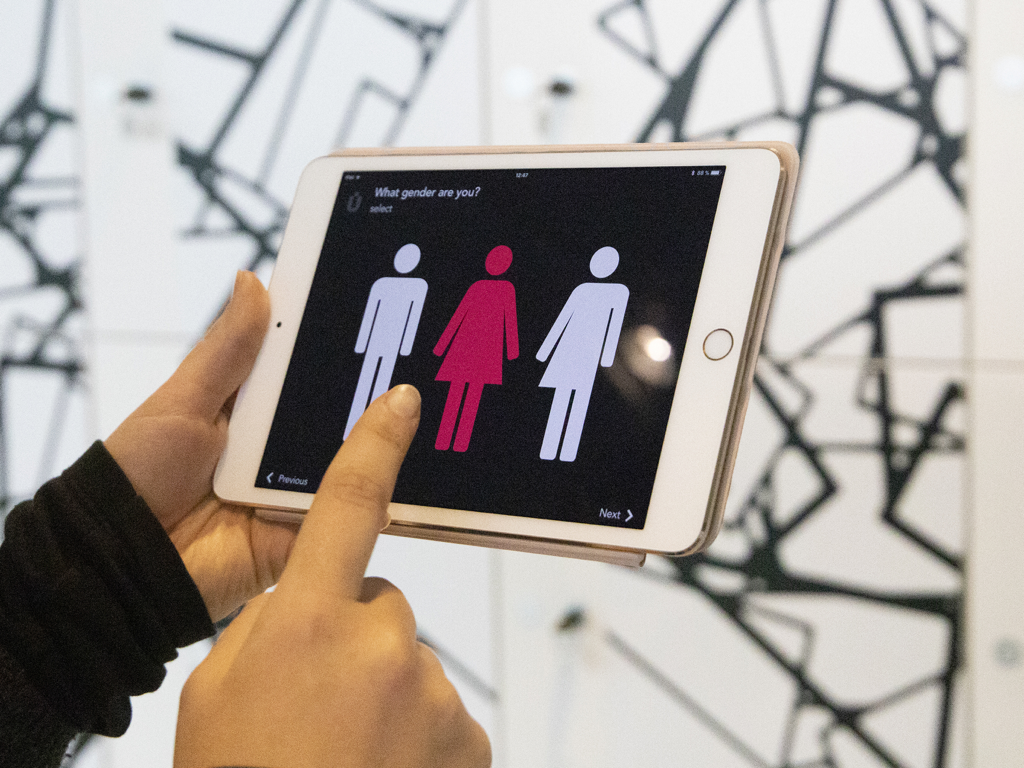 A museum visitor using the Muse tablet app to answer a demographic survey question