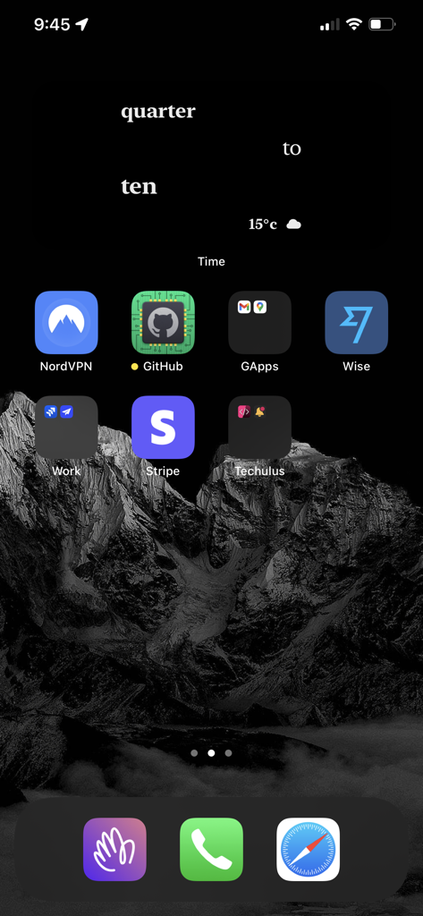 Configuração minimalista de iPhone apresentando um widget de relógio de texto branco em uma paisagem de montanha preta.