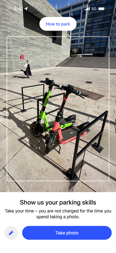 Pantalla de la app Ruter que muestra patinetes eléctricos aparcados en un aparcamiento y un botón para tomar una foto para la verificación del aparcamiento