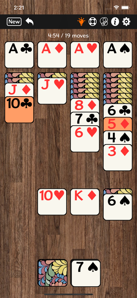 Jugabilidad de solitario Klondike que muestra cartas grandes fáciles de leer en un fondo de madera