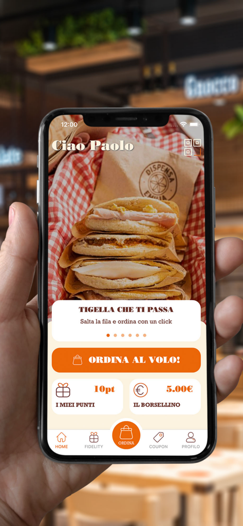 Dispensa Emilia - Mano sosteniendo un smartphone que muestra la pantalla de inicio de la aplicación de comida Dispensa Emilia con puntos de fidelidad y un botón de pedido