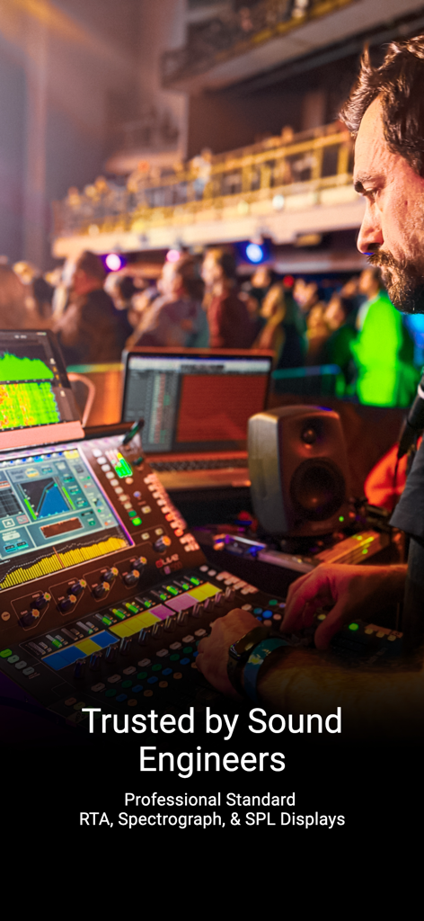 A professional sound engineer at a mixing console using Smaart RTA software in a live concert venue.