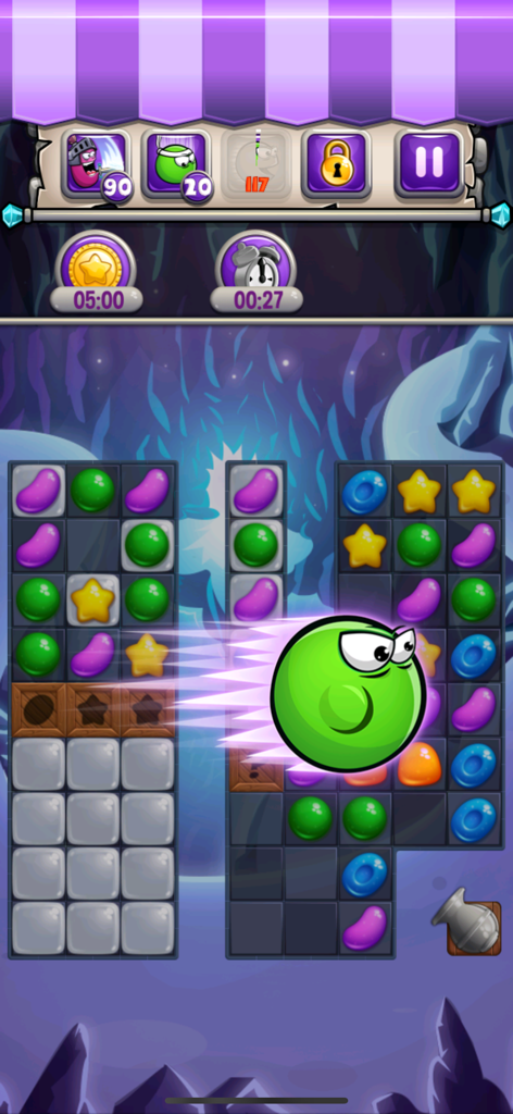 Un nivel de puzzle de combinar 3 en Jewel World Candy Deluxe mostrando coloridos caramelos y un personaje especial verde en acción