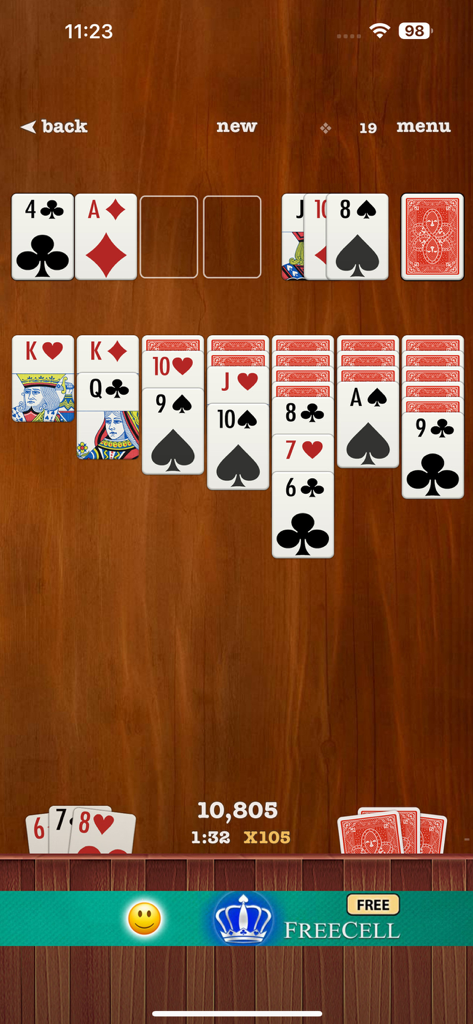 Classic Klondike Solitaire gameplay featuring large easy-to-read card symbols on a dark wood background