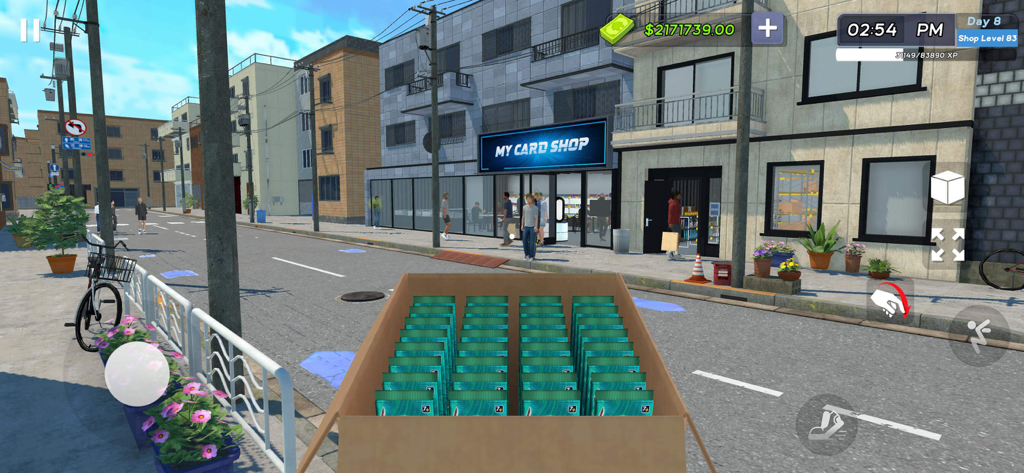 Vista en primera persona de un jugador sosteniendo una caja de paquetes de cartas frente a su tienda de cartas personalizada en una calle de la ciudad