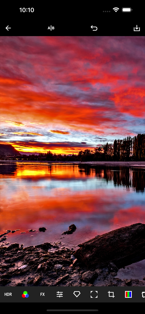 HDR Maxアプリインターフェースで編集中の、鮮やかなオレンジと紫の雲を持つ風景の夕日写真