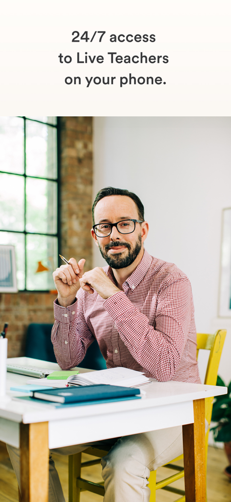 EF Corporate Learning - Un profesor profesional masculino sentado en un escritorio representando acceso móvil 24/7 a instructores en vivo
