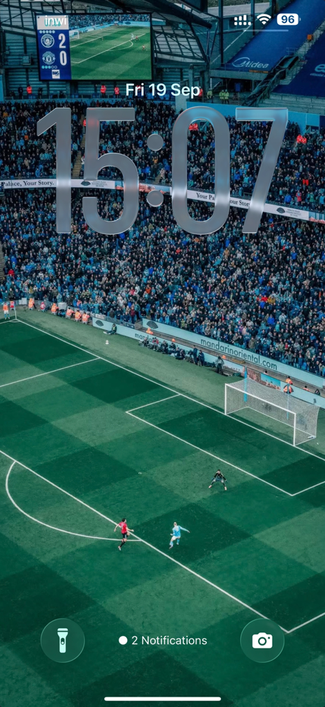 iPhone-Sperrbildschirm mit einem hochauflösenden Fußballstadion-Wallpaper mit laufendem Spiel