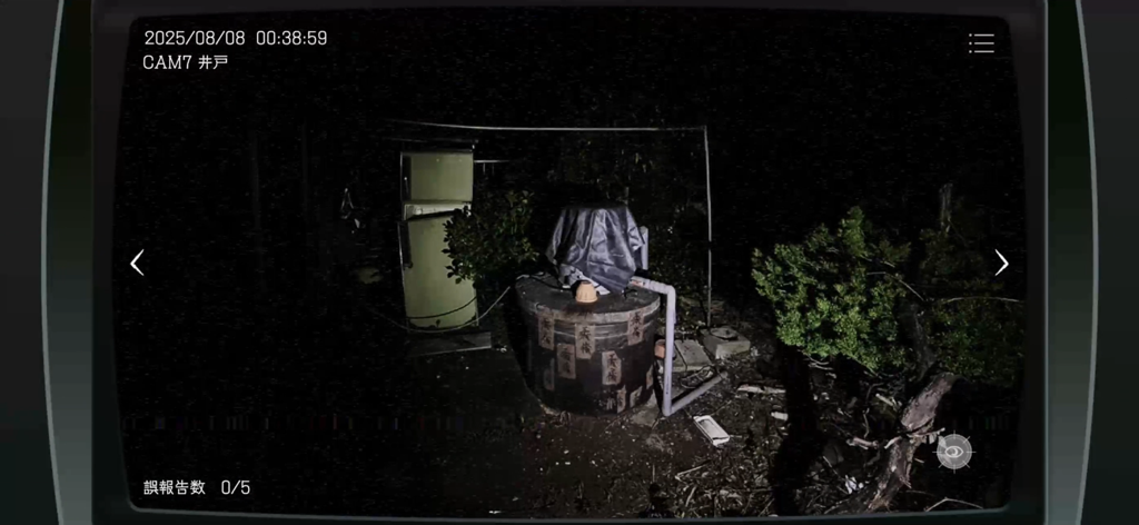 Japan Stigmatized Property - 日本の心霊物件のホラーゲームで、石の井戸と古い冷蔵庫の暗い夜間の監視カメラ映像。