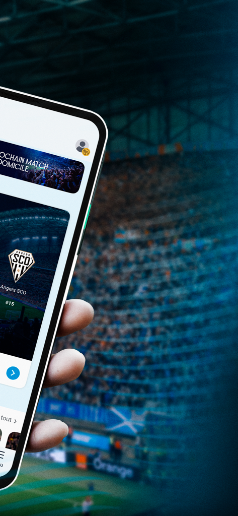 Main tenant un smartphone affichant le calendrier des matchs de l'application officielle de l'Olympique de Marseille sur fond de stade