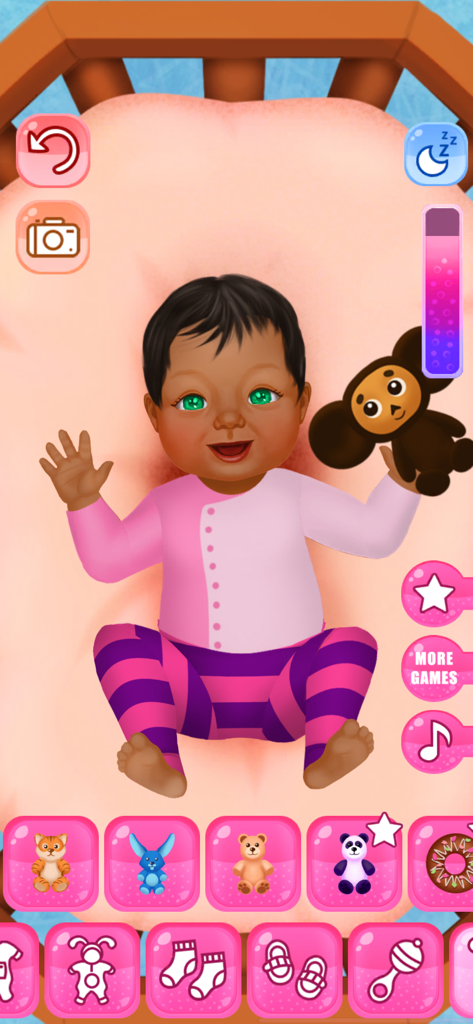 Pantalla de juego de los Juegos de Vestir y Guardería para Bebés que muestra un bebé sonriente en una cuna con varias opciones de personalización de ropa y juguetes.