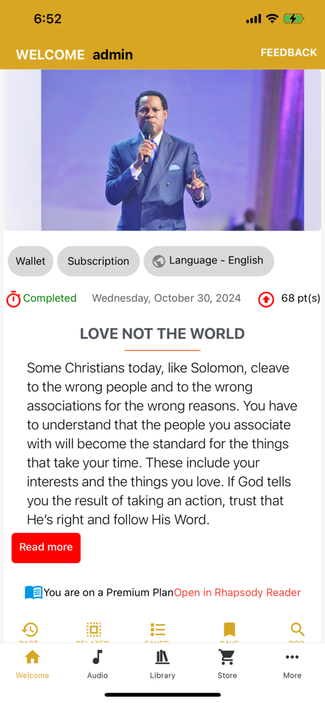 Interfaz de la aplicación móvil Rhapsody of Realities que muestra un artículo devocional diario titulado 'Ama No Al Mundo' y una foto del Pastor Chris.