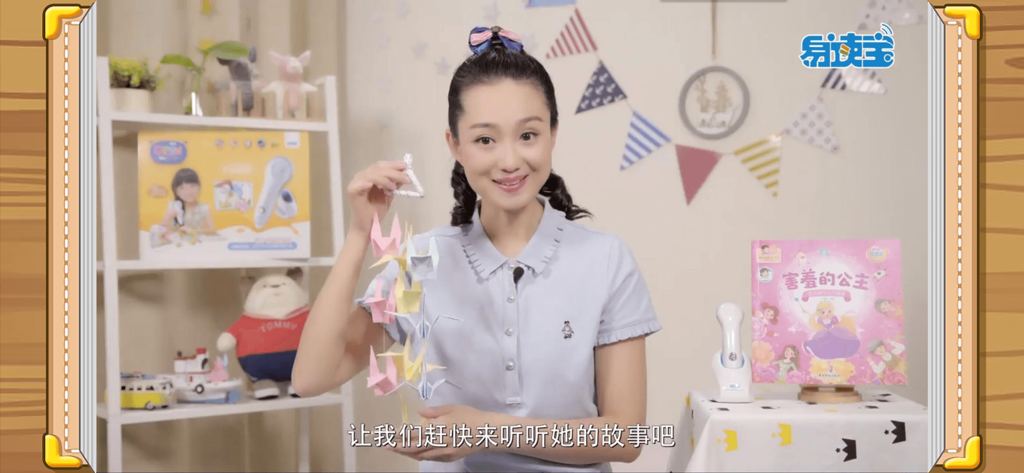 易读宝点读 - A teacher narrating a story in the Yidubao Qpen app with a smart reading pen and children's book in the background