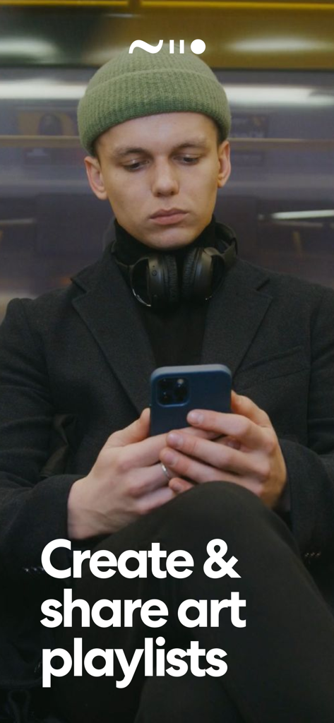 A young man using the Niio Art app on his smartphone to create and share digital art playlists