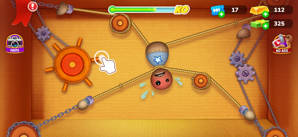 Captura de pantalla del juego Kick the Buddy mostrando al personaje de muñeco de trapo interactuando con cuerdas y poleas en un entorno sandbox