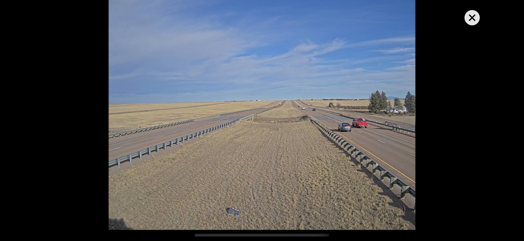 Real-time traffic camera view of a clear Montana highway with vehicles and open plains