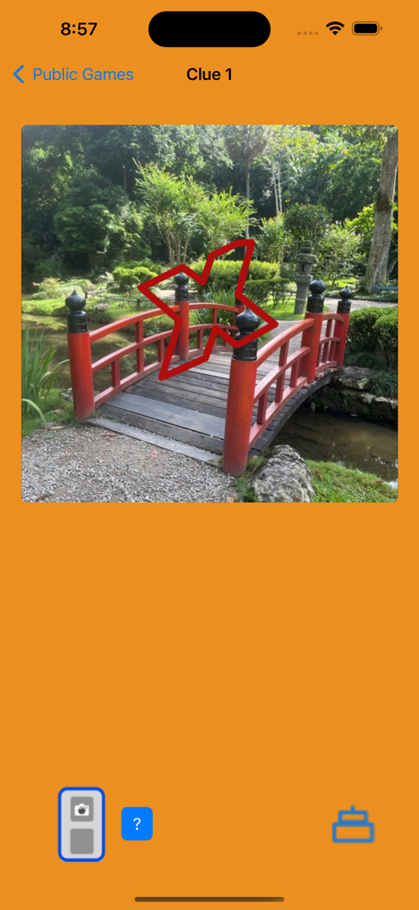 Treasure Hunt By Photos - Mobile app screen showing a photo clue of a small red bridge in a garden for a scavenger hunt