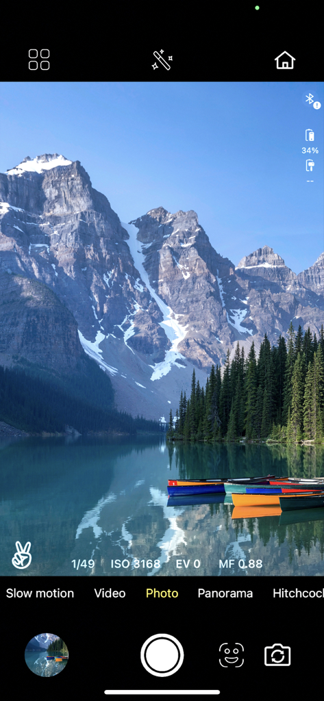 IZI GO - IZI GO app camera interface showing manual photography settings over a scenic mountain lake landscape