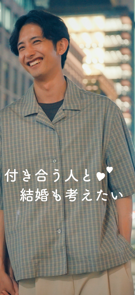 Un Japonais souriant, vêtu d'une chemise à carreaux avec un texte japonais exprimant son intérêt pour le mariage, sur l'application de rencontre Omiai.
