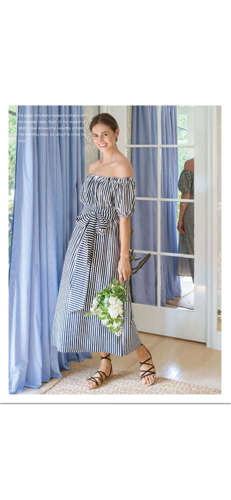 MILIEU Magazine - A woman modeling a striped off the shoulder dress and holding flowers in a bright interior