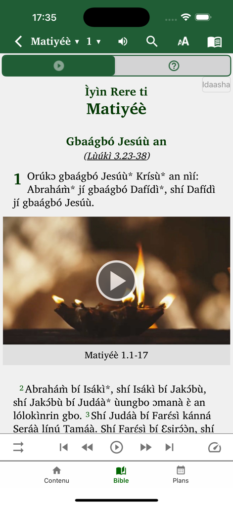 Benin Bible - A screenshot of the Benin Bible app showing scripture text in Idaasha with an integrated video player and playback controls.