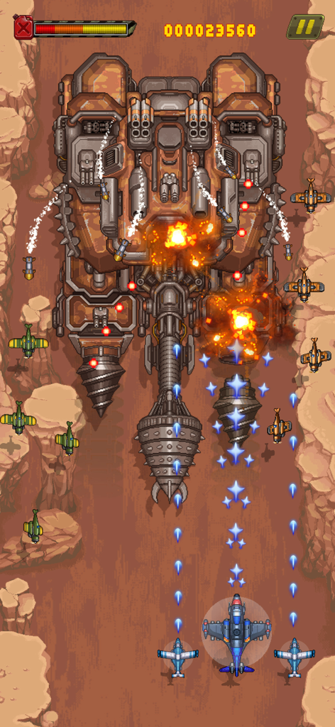 Top down arcade shooter gameplay showing a player plane fighting a giant mechanical boss with drills in a desert canyon.