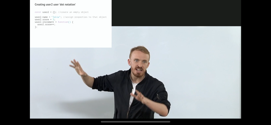 An expert instructor teaching a JavaScript lesson on object dot notation within the Frontend Masters app.