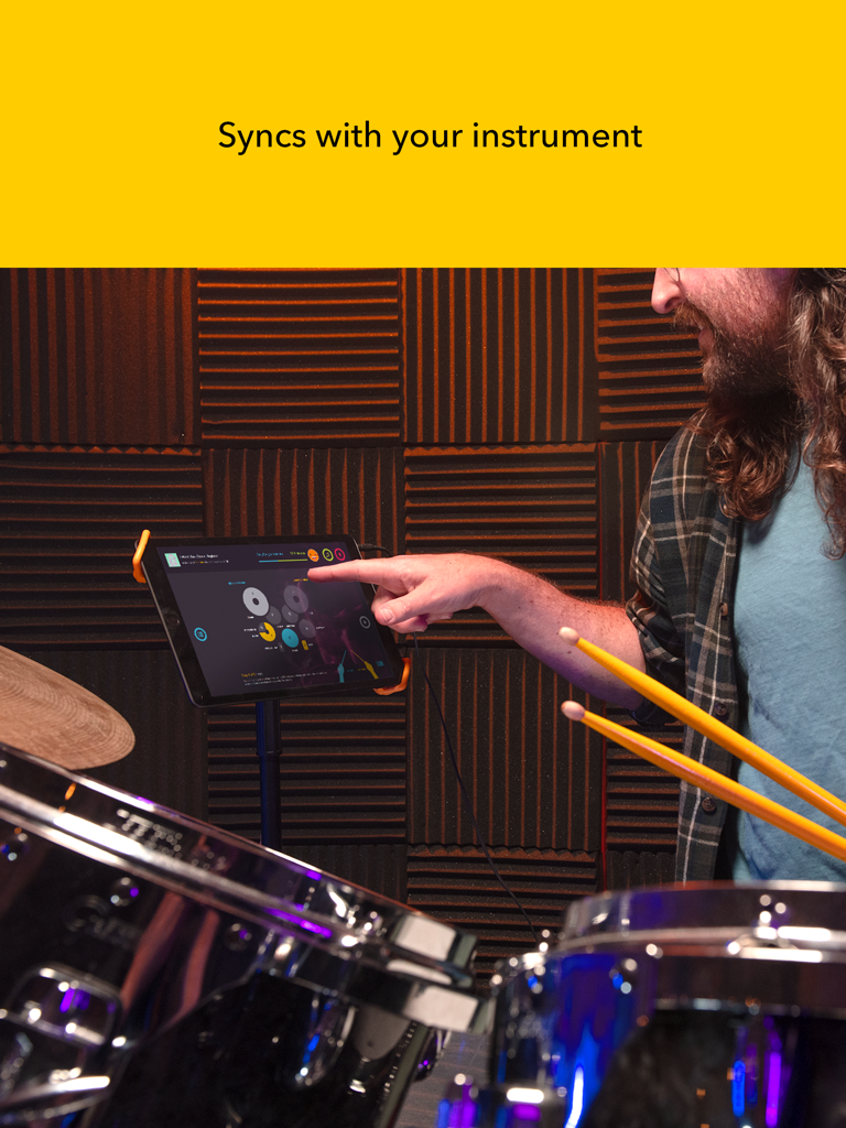 Melodics for iPad - A musician using the Melodics app on an iPad synced with an electronic drum kit