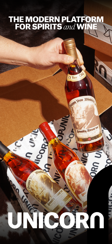 Una mano che tiene una bottiglia di raro bourbon Pappy Van Winkle sopra una scatola di spedizione per aste.