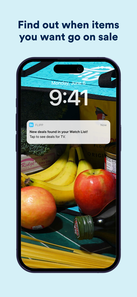 Un smartphone mostrando una notificación de la aplicación Flipp sobre nuevas ofertas encontradas para artículos en una lista de seguimiento del usuario sobre un fondo de comestibles frescos.