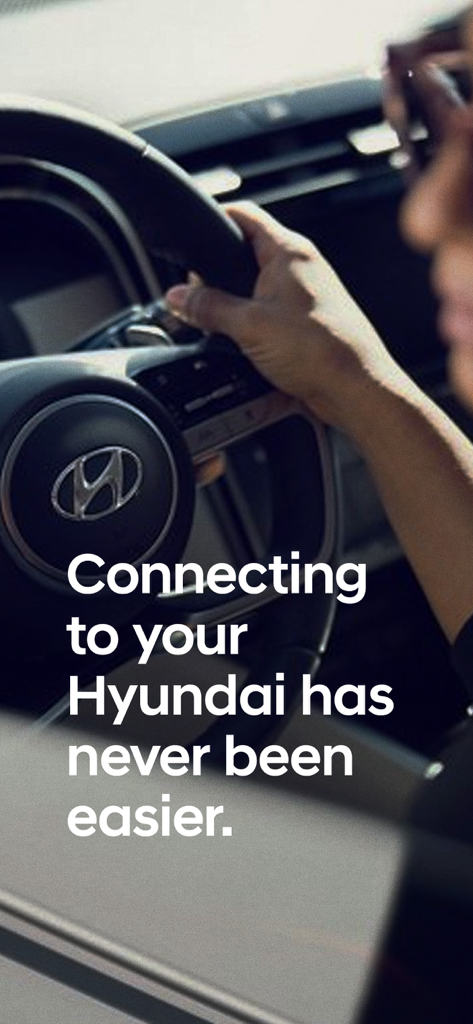 A driver's hand on a Hyundai steering wheel with text about easy vehicle connectivity