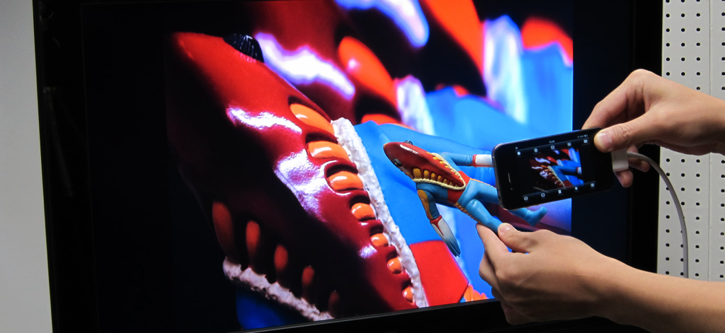 CameraVision - iPhone using CameraVision app to project a live camera feed of a small figurine onto a large TV monitor