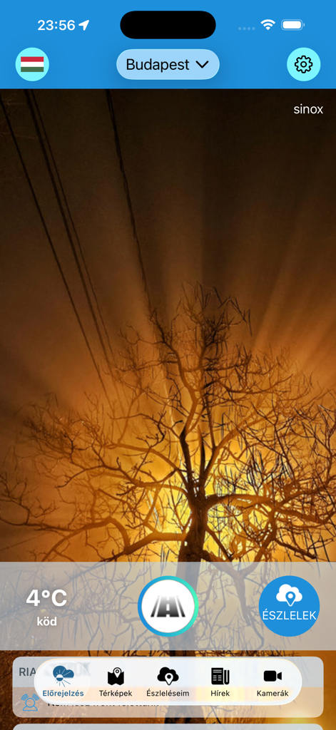 Időkép - Captura de pantalla de la aplicación meteorológica Idokep mostrando 4 grados y niebla en Budapest con un pintoresco atardecer y fondo de árboles