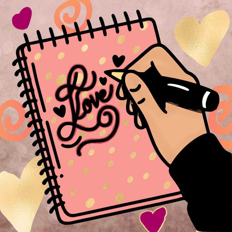a hand writing “love” in calligraphy on a notebook