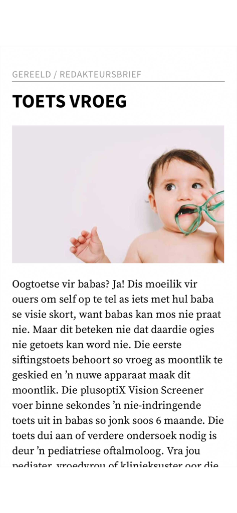 A baby holding green glasses in an Afrikaans parenting magazine article titled Toets Vroeg regarding early vision screening.