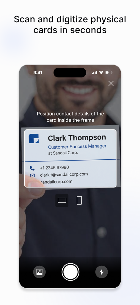 A smartphone scanning a physical business card to digitize contact information using the Uniqode app